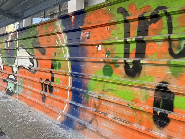 Graffiti that Neeraj spotted recently on a ridged metal wall in Barcelona. Orange background with black, lime green, blue, and white abstract lines spray painted on top.