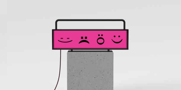 Image of a long pink screen with black emoji faces made with typography, showing a variety of expressions.